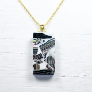 Rectangular black-and-white patterned pendant on gold chain