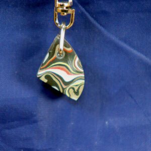Colorful marbled triangular pendant on blue fabric