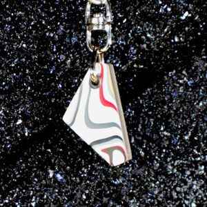 Swirled resin pendant keychain on black glitter