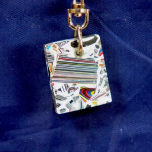 Colorful striped glass pendant on blue fabric