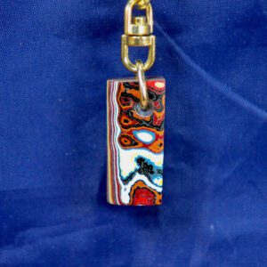 Multicolored rectangular pendant keychain on blue background