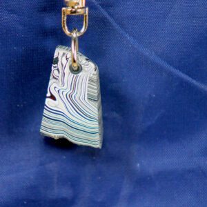 Swirled striped pendant hanging against blue fabric